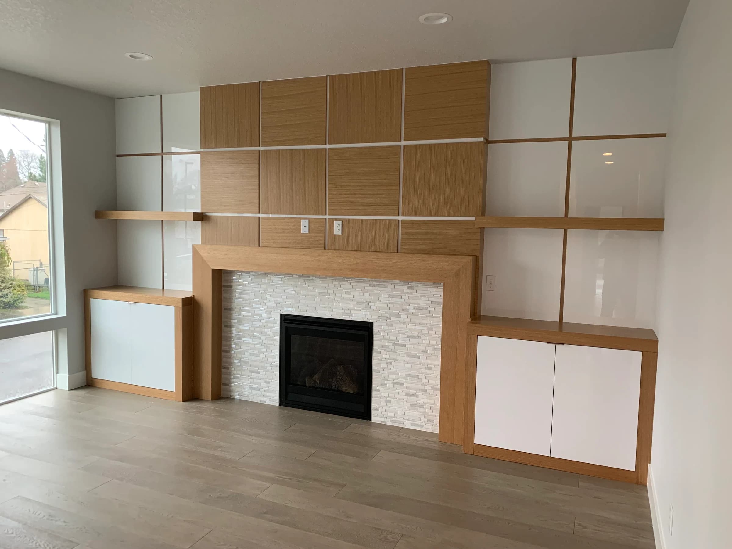 NS Wood Finishing project: a fireplace wall with wood panels, floating shelves and white built-in doors