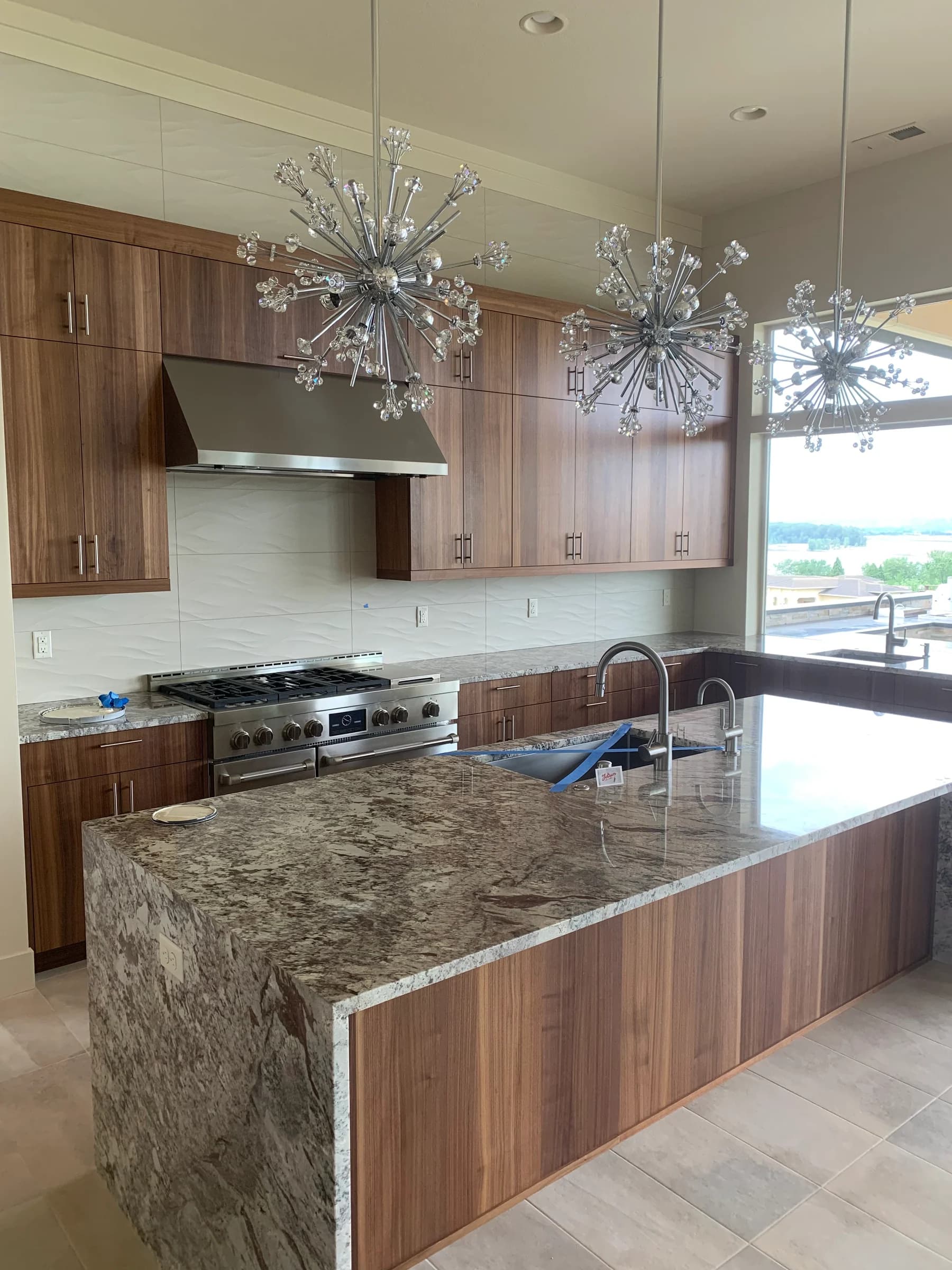NS Wood Finishing project: wood-grain kitchen cabinetry and an island with a stone waterfall countertop