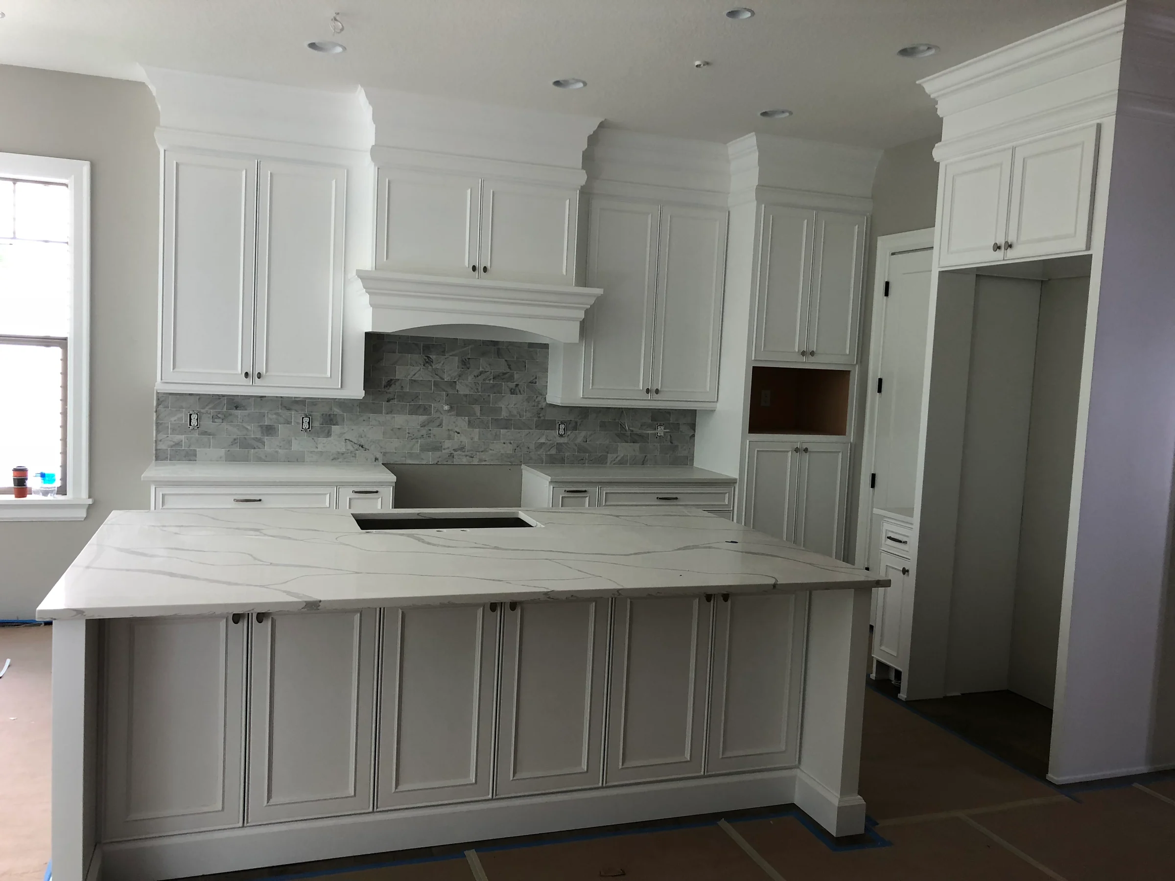 NS Wood Finishing project: light painted kitchen cabinets with framed doors and a matching paneled island