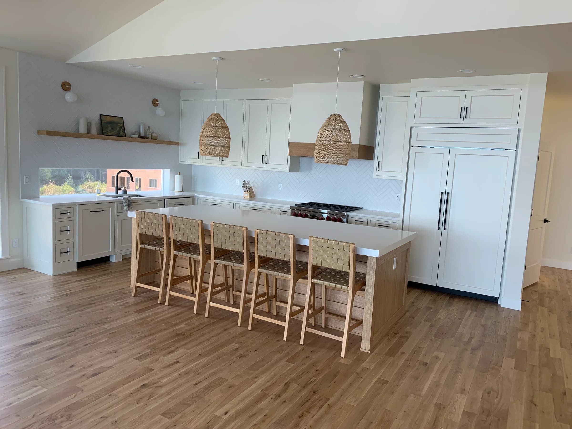 NS Wood Finishing project: white framed kitchen cabinets with a wood island, black pulls and woven pendant lights