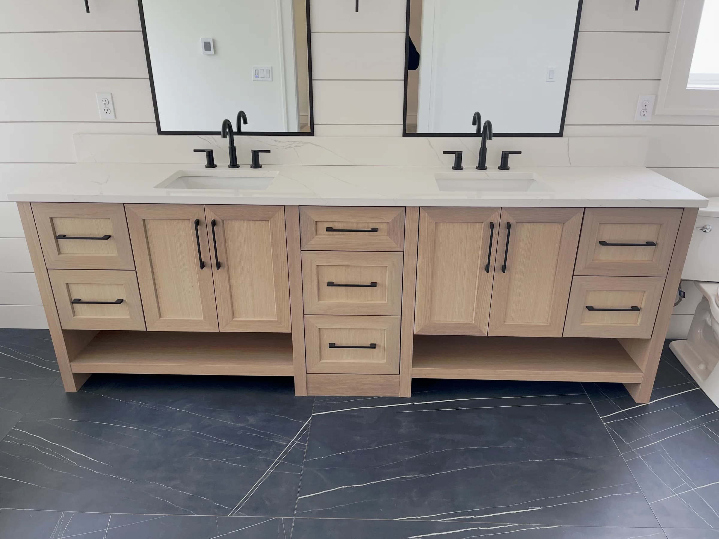 NS Wood Finishing project: a light wood double vanity with framed doors, drawers and black hardware