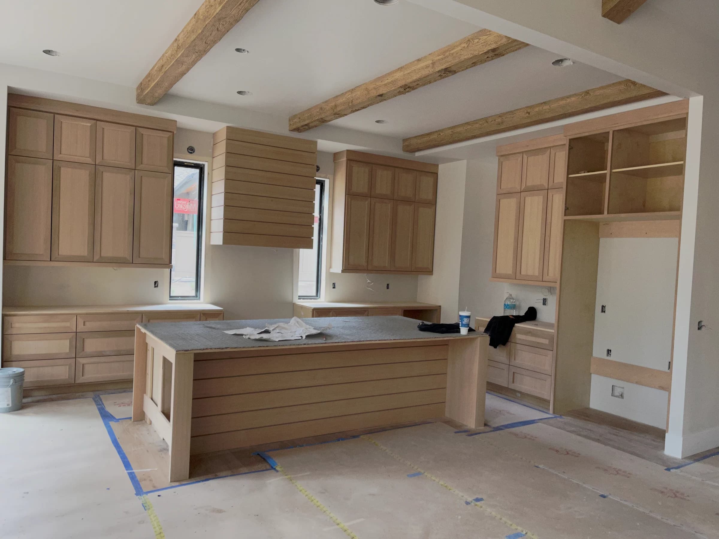 NS Wood Finishing project: a kitchen in progress with wood cabinetry, a matching hood and exposed ceiling beams